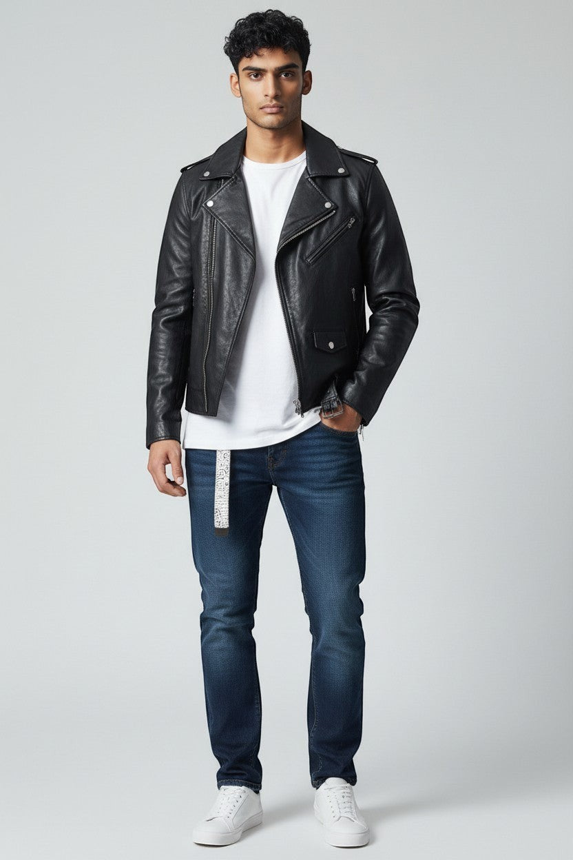 Model wearing a Scarlett Stitch black leather biker jacket with silver hardware, white t-shirt, and blue jeans.