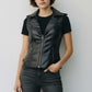 Scarlett Stitch black faux leather moto vest with lapel collar, zip front, and zippered pockets. Tailored fit.