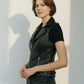 Scarlett Stitch black faux leather moto vest with lapel collar, zip accents, and buckle tabs. Sleeveless, tailored fit.