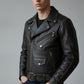 Scarlett Stitch black leather biker jacket with contrast stitching, metal zippers, and waist belt on a male model.