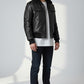Model wearing a Scarlett Stitch black leather bomber jacket with a faux-shearling collar, utility pocket, and ribbed trim