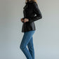 Scarlett Stitch black leather double-breasted jacket with silver buttons and waist belt worn by a blonde model.