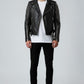 Scarlett Stitch black leather biker jacket with silver studs on sleeves, asymmetrical zip, and belted waist on model.