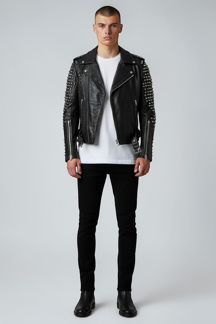 Scarlett Stitch black leather biker jacket with silver studs on sleeves, asymmetrical zip, and belted waist on model.