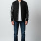 Scarlett Stitch Men's black wool-blend varsity jacket with genuine leather sleeves, snap front, and ribbed trim.