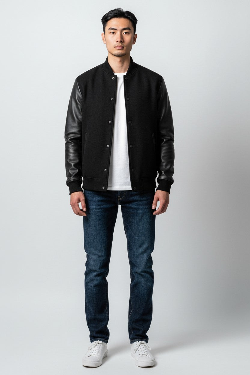 Scarlett Stitch Men's black wool-blend varsity jacket with genuine leather sleeves, snap front, and ribbed trim.