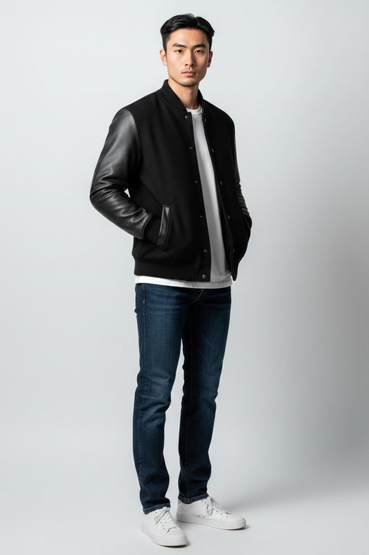 Scarlett Stitch Men's black wool-blend varsity jacket with genuine leather sleeves, snap front, and welt pockets.