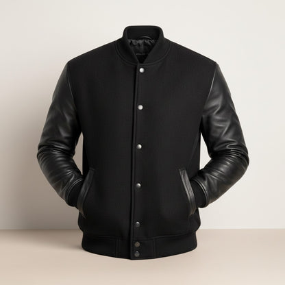 Scarlett Stitch Men's black wool-blend varsity jacket with genuine leather sleeves, snap front, and ribbed trim.
