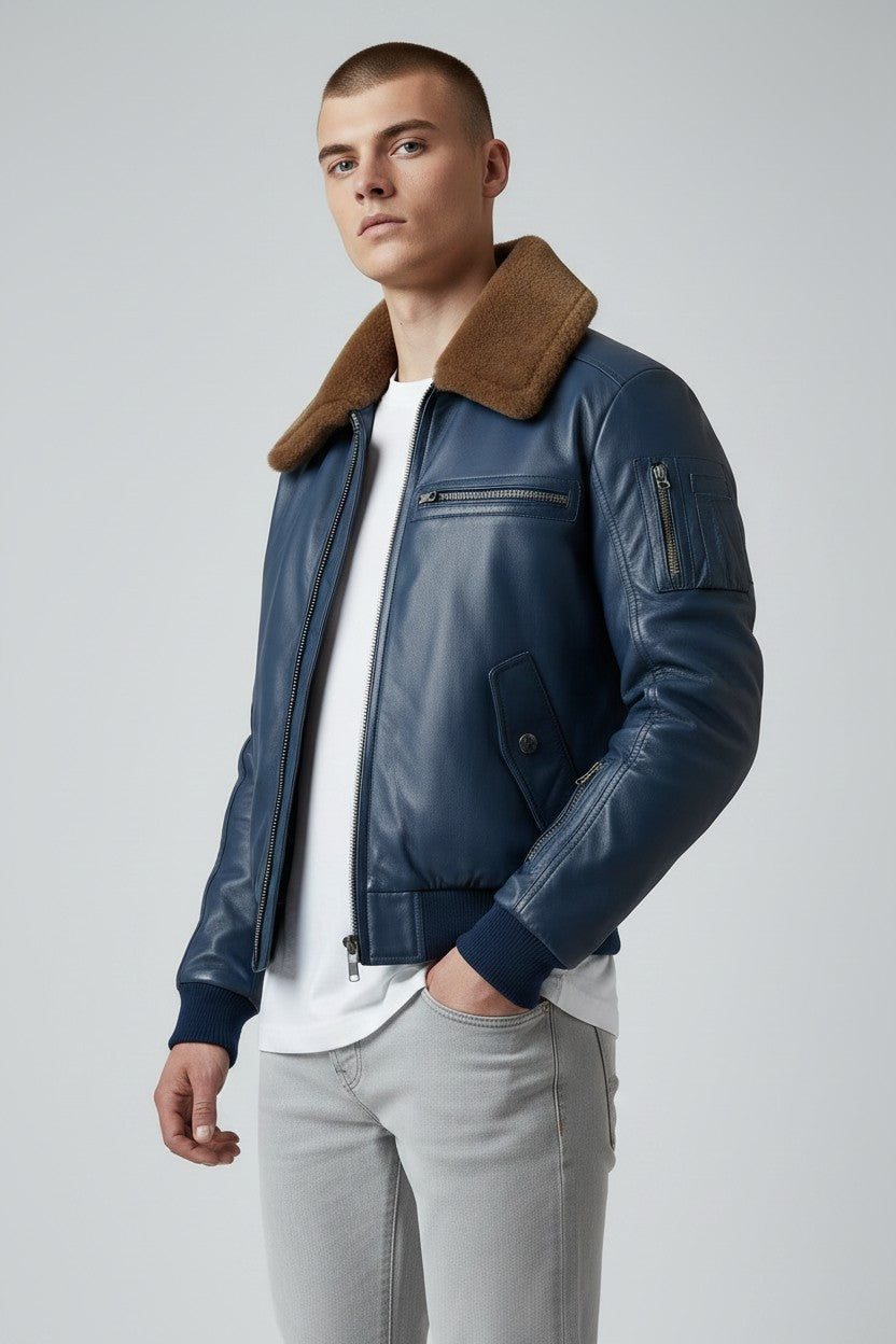 Scarlett Stitch men's blue leather bomber jacket with a brown faux-fur collar, ribbed cuffs, and zippered sleeve pocket.