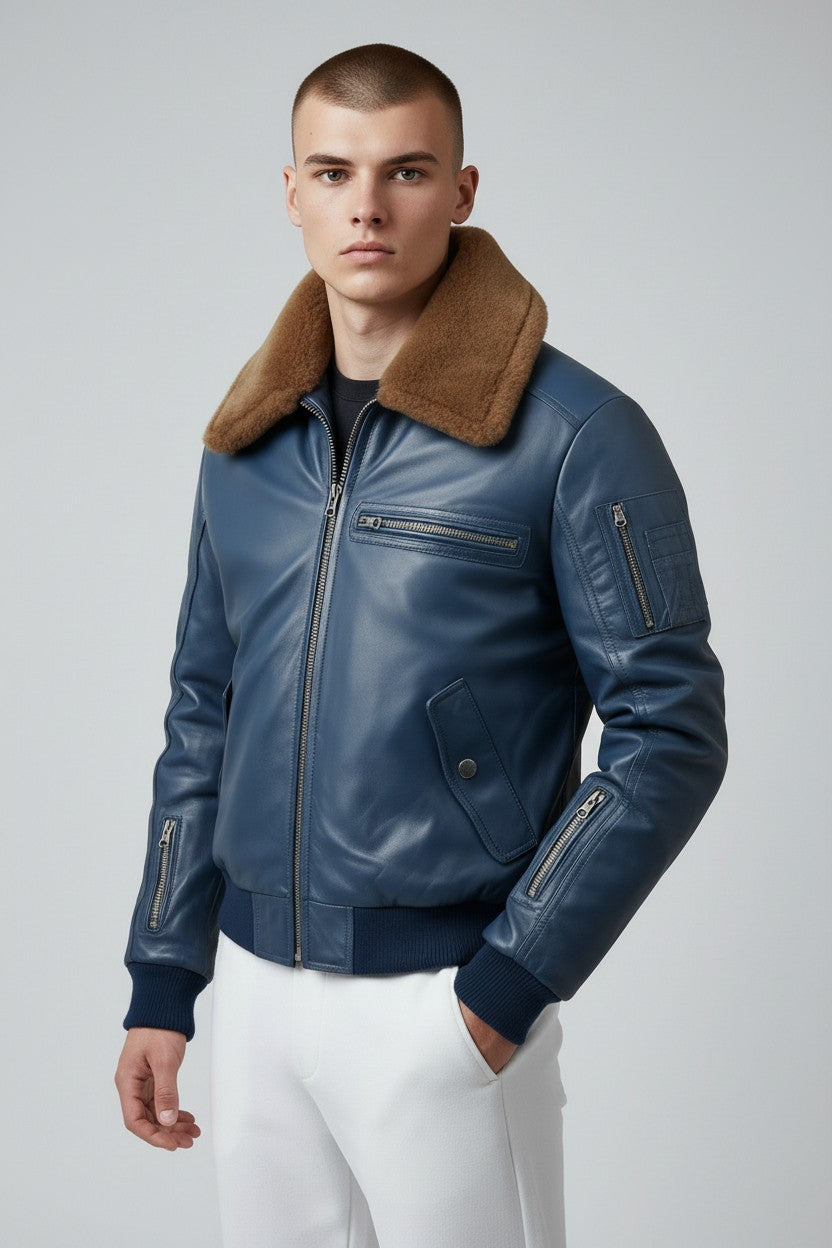 Scarlett Stitch men's blue leather bomber jacket with a brown faux-fur collar, ribbed cuffs, and utility sleeve pocket.