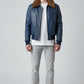 Scarlett Stitch men's blue leather bomber jacket with a brown faux-fur collar, ribbed cuffs, and metal zipper details.
