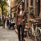 Scarlett Stitch brown distressed leather blazer with notched lapels worn by a woman on a city street.
