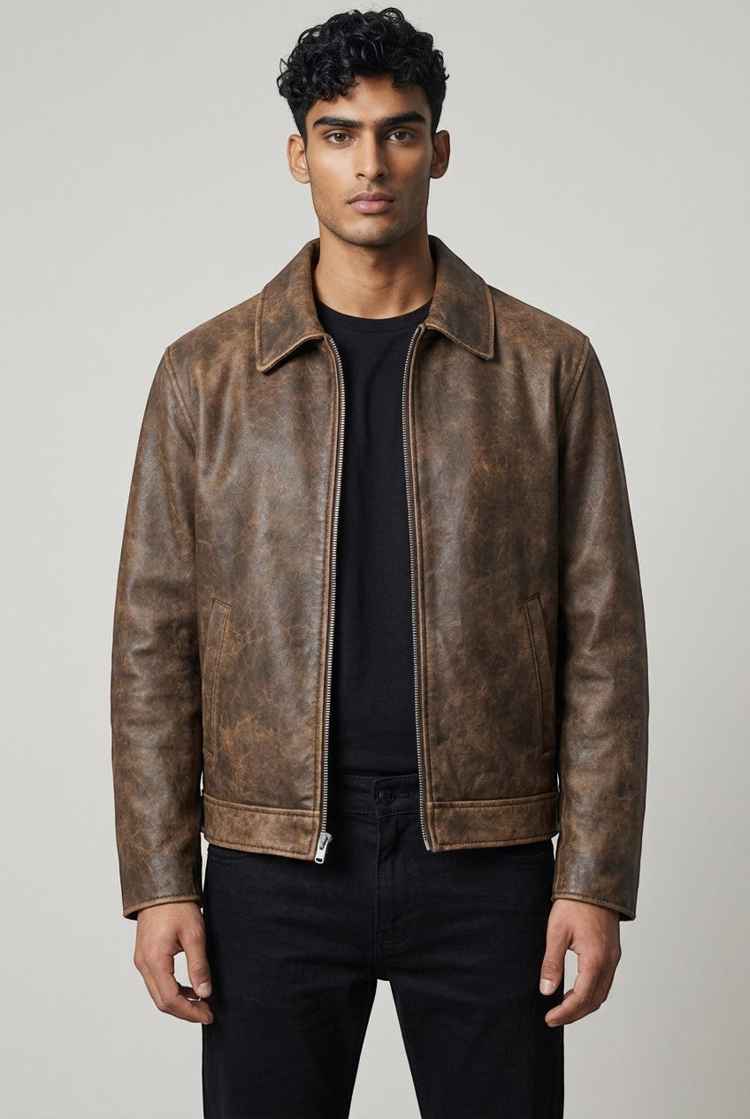 Model wearing a Scarlett Stitch brown distressed leather bomber jacket with a structured collar and front zipper.
