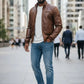 Scarlett Stitch Men's brown faux leather bomber jacket with stand-up collar, zip front, and quilted shoulders.