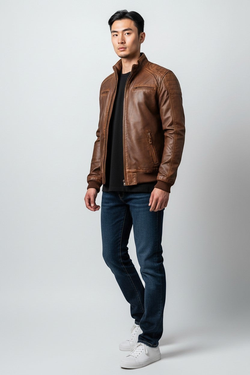 Scarlett Stitch brown faux leather bomber jacket with stand collar, zip front, ribbed cuffs and hem, and zippered pockets.