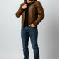Scarlett Stitch Men's distressed brown faux leather hooded bomber jacket with ribbed cuffs and zip pockets.
