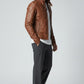Scarlett Stitch brown faux leather jacket with stand collar worn by a model in a white t-shirt and grey trousers.