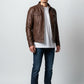 Man wearing a brown Scarlett Stitch faux leather utility jacket with snap pockets and stand-up collar over a white tee.