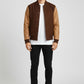 Scarlett Stitch Men's brown wool-blend varsity bomber jacket with tan leather sleeves, ribbed collar, cuffs, hem and snap closure.