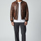 Scarlett Stitch Men's distressed brown leather bomber jacket with shirt collar, zippered front, and ribbed cuffs.