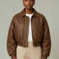 Scarlett Stitch distressed brown leather cropped bomber jacket with collar and zip-front closure.