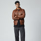 Scarlett Stitch men's brown genuine leather bomber jacket with ribbed collar, cuffs, and hem. Features zipper closure and flap pockets.