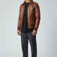Scarlett Stitch Men's genuine leather bomber jacket in warm brown with ribbed collar, cuffs, and hem. Features zip closure and flap pockets.