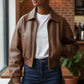 Scarlett Stitch distressed brown leather cropped bomber jacket with collar, zip-front, and elasticated cuffs.