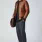 Scarlett Stitch men's brown quilted faux leather bomber jacket with ribbed collar, cuffs, and hem. Features chest and side pockets.