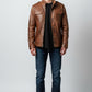 Scarlett Stitch men's brown leather field jacket with chest pockets, stand-up collar, and epaulettes on a male model.