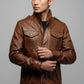 Scarlett Stitch men's brown leather field jacket with chest pockets, stand-up collar, and snap-button closure.