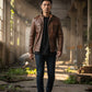 Scarlett Stitch men's brown leather field jacket with chest pockets and stand-up collar worn by a man in an industrial space