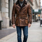 Scarlett Stitch brown distressed leather double-breasted jacket with shearling lining worn by a man on a city street.