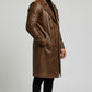Scarlett Stitch men's brown distressed leather double-breasted trench coat worn by a model in a side profile view.