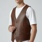 Scarlett Stitch distressed brown leather V-neck button-front vest with flap pockets and adjustable side tabs.