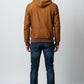Scarlett Stitch brown suede bomber jacket with hood, zip closure, and ribbed cuffs and hem. Worn by a man with jeans.