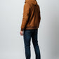 Scarlett Stitch brown suede bomber jacket with hood on a man wearing jeans and white sneakers.