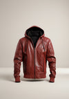 Scarlett Stitch Men's hooded leather bomber jacket in deep burgundy with quilted shoulders and zippered pockets.