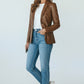 Model wearing a Scarlett Stitch cognac brown leather blazer with notched lapels, white tee, and blue jeans.