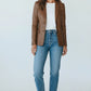 Model wearing a Scarlett Stitch cognac brown leather blazer with a white tee, blue jeans, and white sneakers.