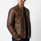 Scarlett Stitch men's distressed brown leather cafe racer jacket with quilted shoulders and zippered pockets.