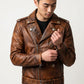 Man wearing a Scarlett Stitch distressed brown leather motorcycle jacket with asymmetrical zip and waist belt.