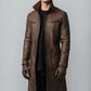 Scarlett Stitch men's distressed brown leather trench coat with a high-neck collar and zippered pockets on a model.