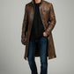Scarlett Stitch men's distressed brown leather trench coat with zippered pockets worn by a model in jeans and sneakers