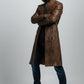 Scarlett Stitch men's distressed brown leather trench coat with a high-neck collar and zippered pockets on a model.