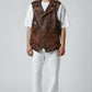 Model wearing a Scarlett Stitch brown distressed leather biker vest with snap buttons over a white t-shirt and pants.