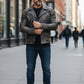 Scarlett Stitch Men's distressed black leather motorcycle jacket with ribbed detailing and zippered pockets.