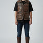 Model wearing a Scarlett Stitch brown distressed leather utility vest with multiple pockets and a zip-front closure.