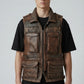 Model wearing a Scarlett Stitch brown distressed leather utility vest with multiple pockets and a zip-front closure.