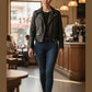 Scarlett Stitch black faux leather moto jacket with embroidered floral back detail, worn by a woman with a shaved head.